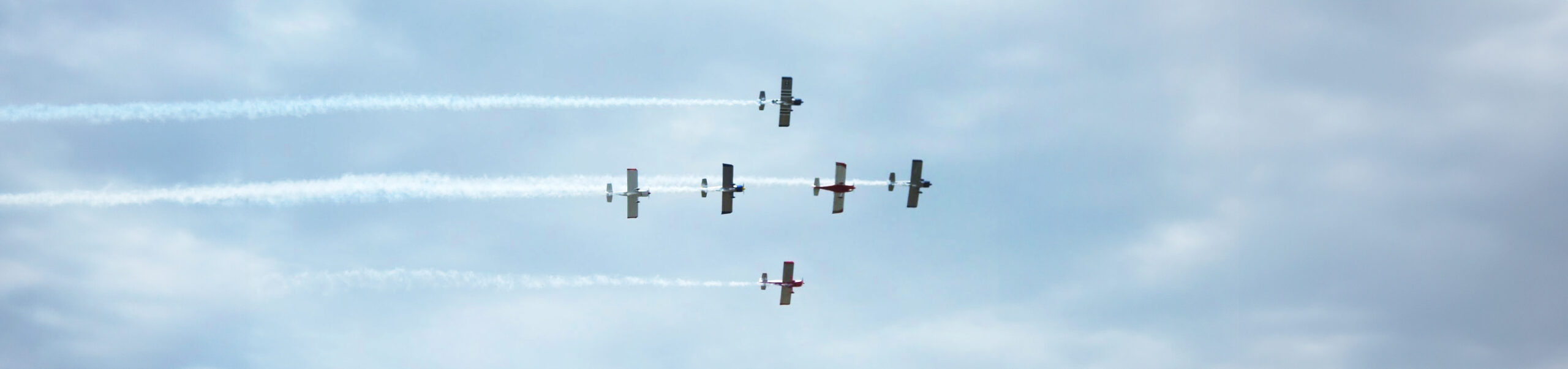 Planes in sky leaving smoke trails